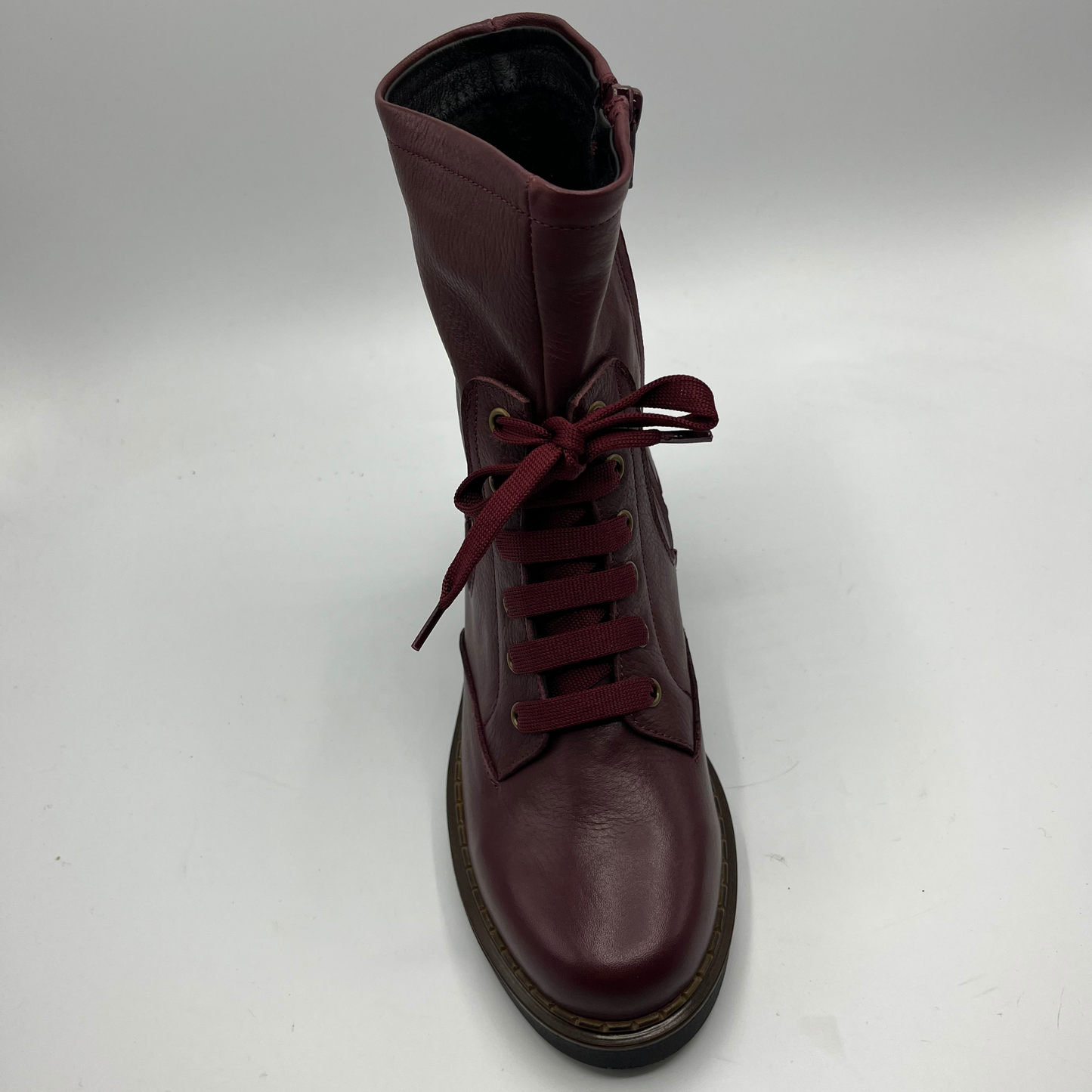 Merlot leather boot with red laces on a white background
