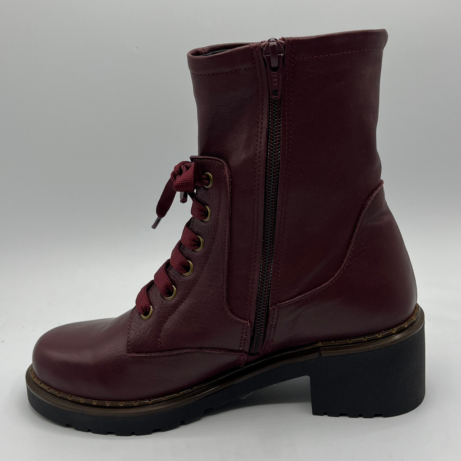 Maroon boot with lace-up design and zipper on a light gray background
