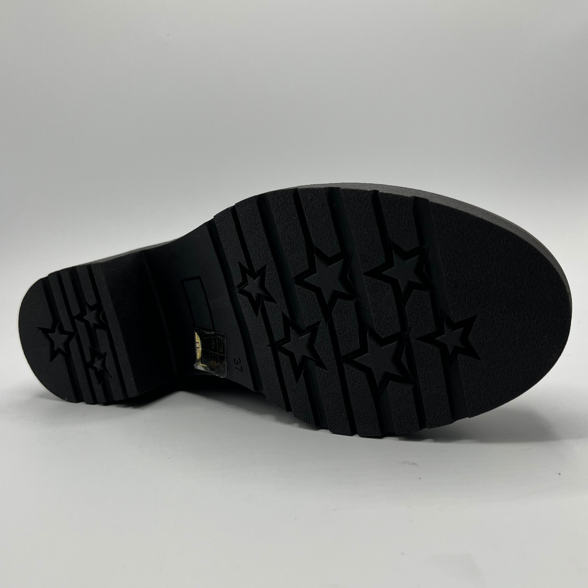Black sole of a shoe with star pattern on a gray background