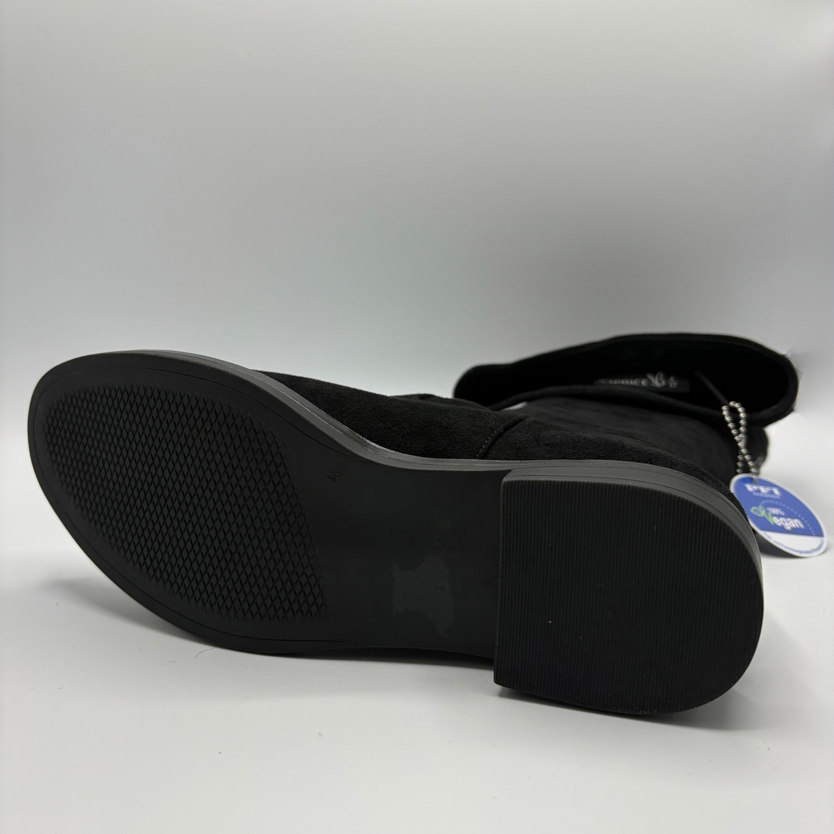Bottom view of a tall black boot on a white background