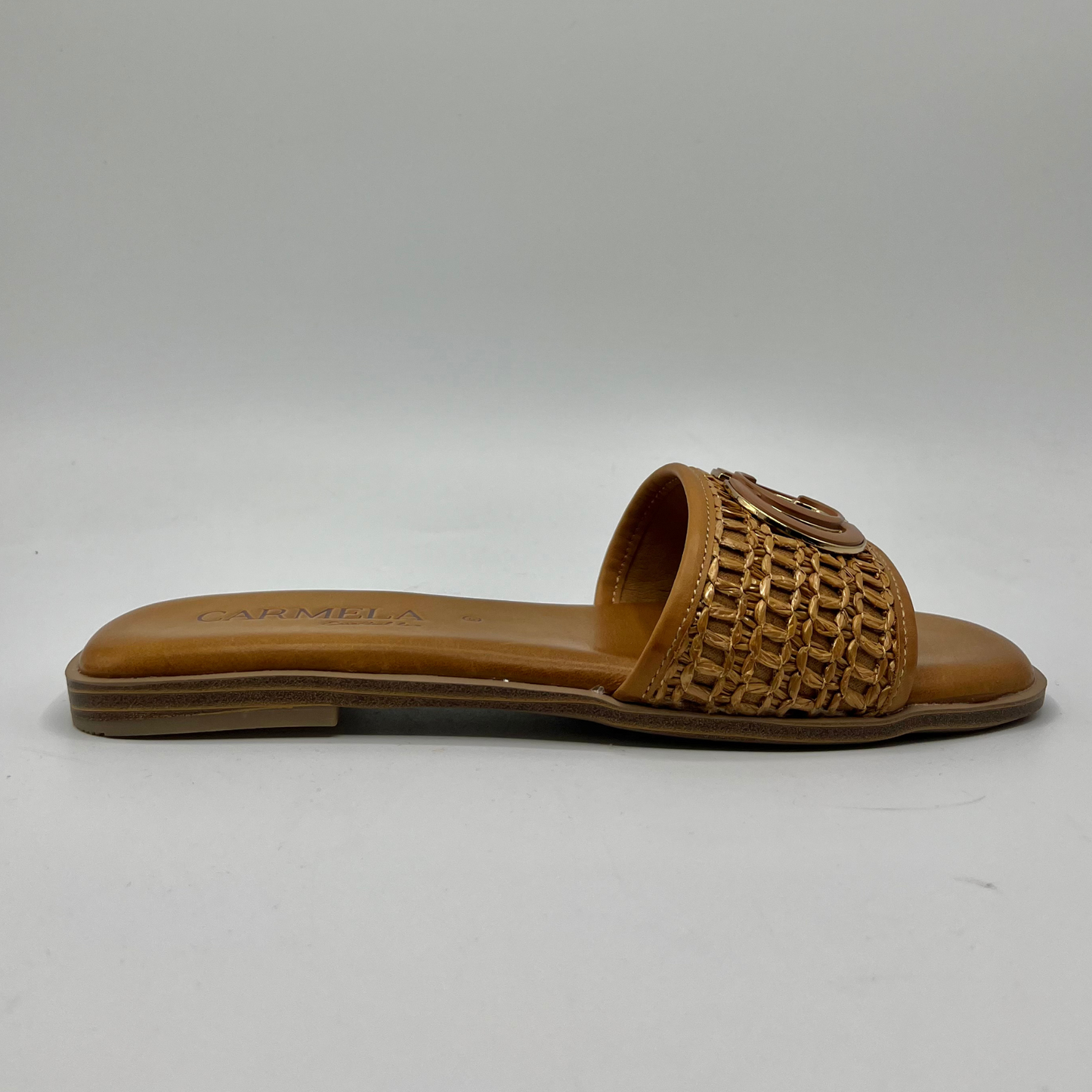 Right facing view of a flat leather lined sandal with a chain pattern on the strap as well as decorative branding.