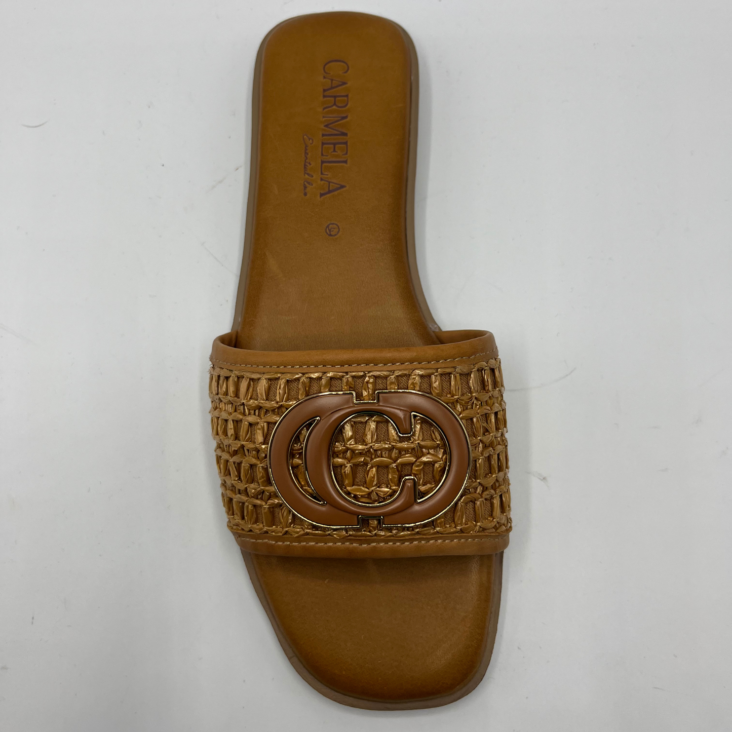 Top view of a flat leather lined sandal with a chain pattern on the strap as well as decorative branding.