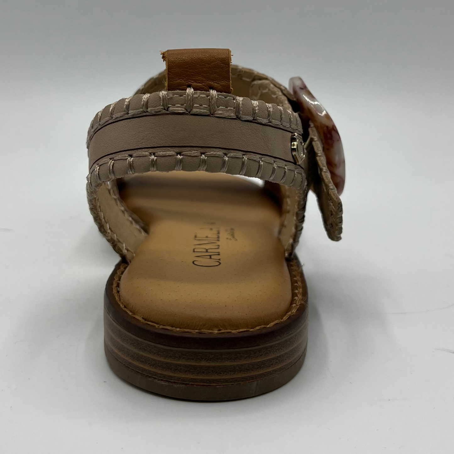 Back view of a leather sandal with a cushioned footbed and an adjustable strap with a tortoise shell buckle.