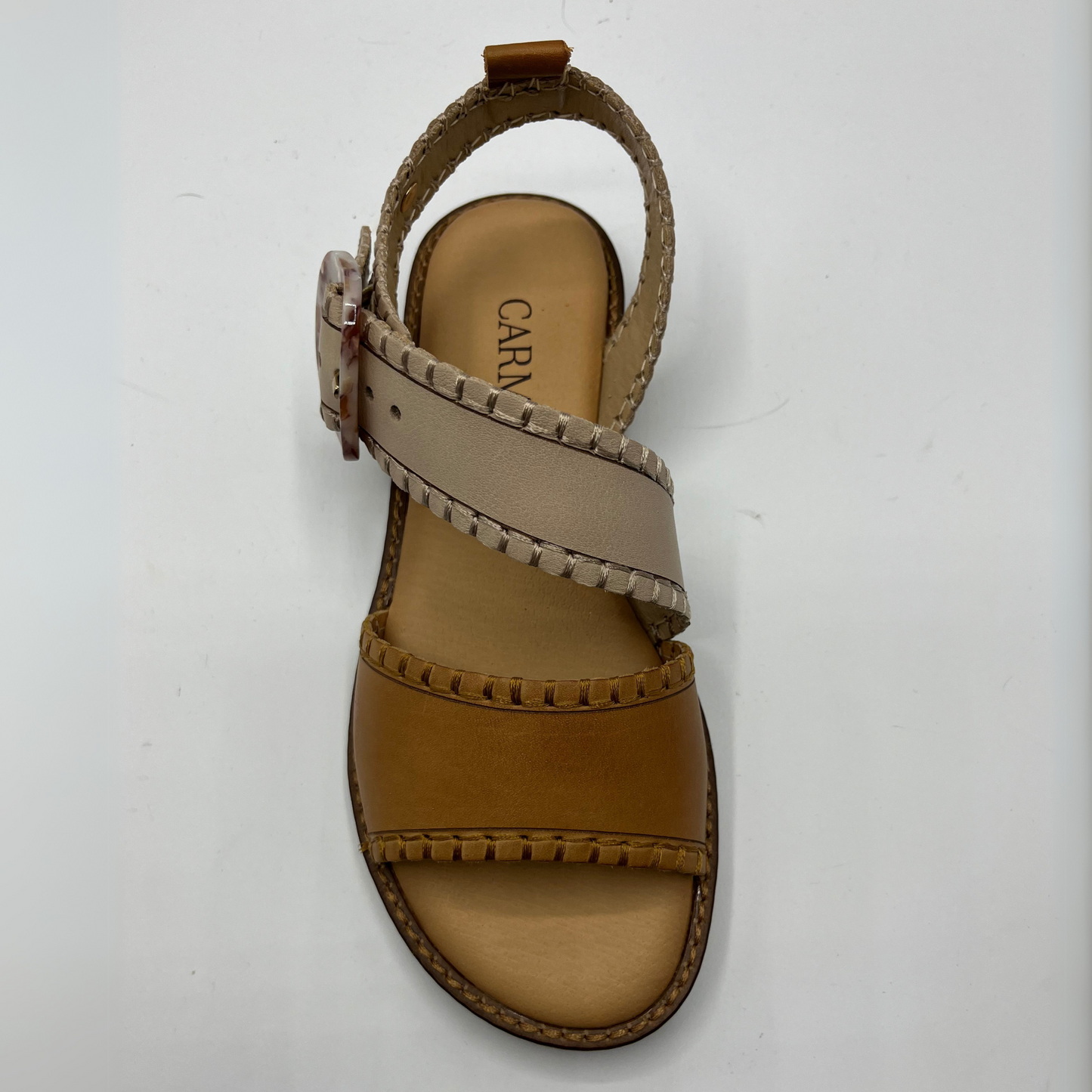 Top view of a leather sandal with a cushioned footbed and an adjustable strap with a tortoise shell buckle.
