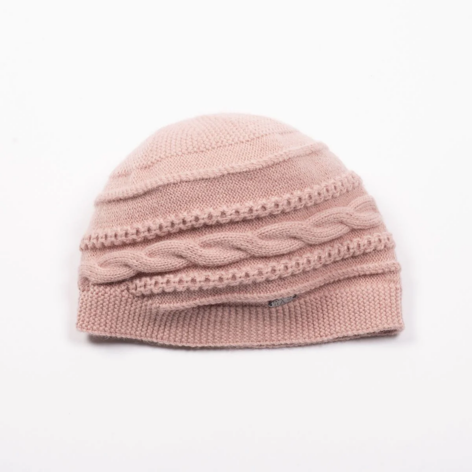 Front view of a round cable knit beanie in a soft pink colour.