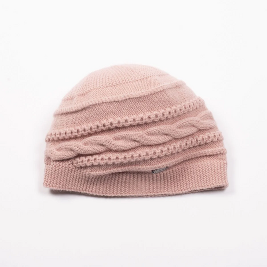 Front view of a round cable knit beanie in a soft pink colour.