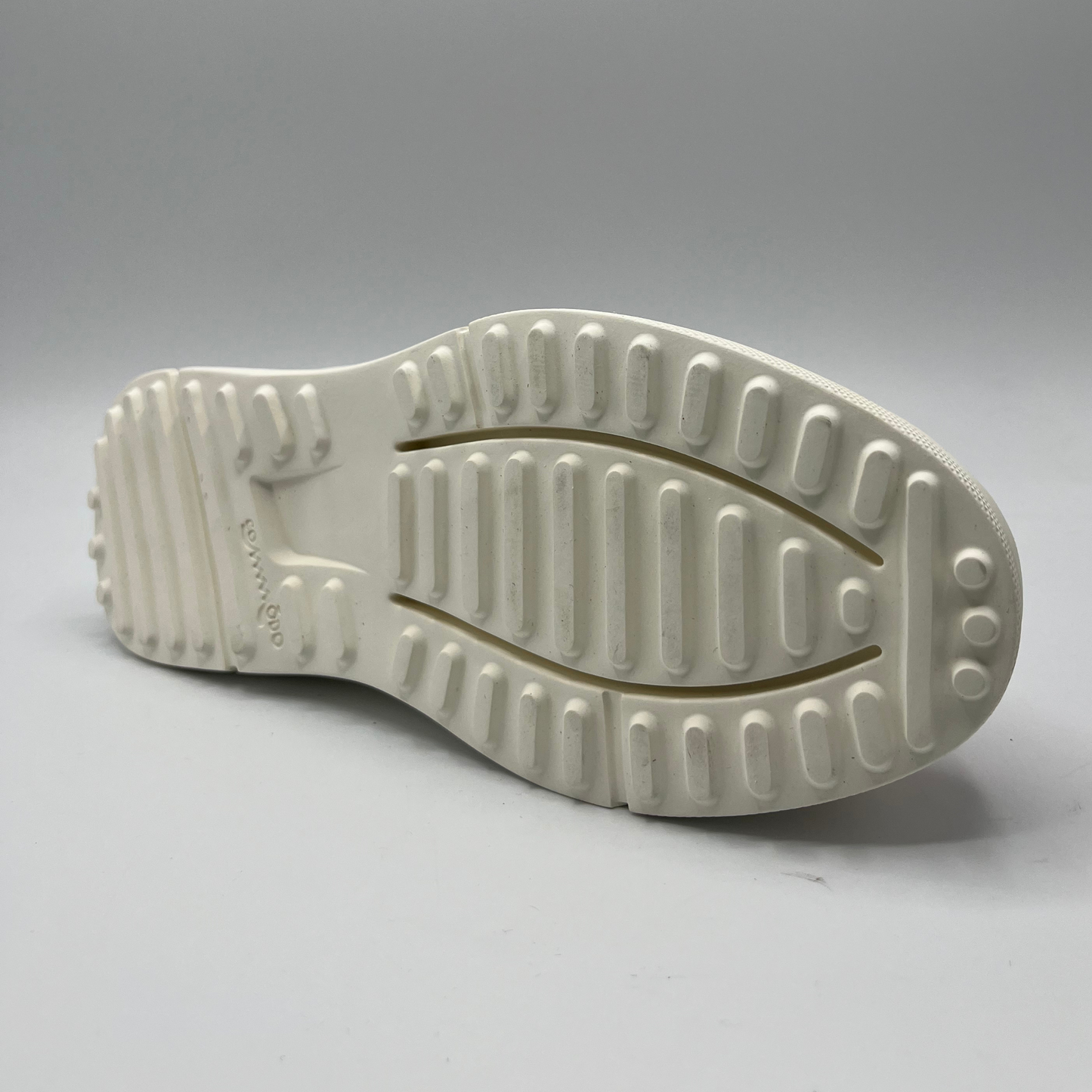 Bottom view of a pink and gold leather sneaker with a thick white rubber outsole. This is a slip on style with elastic gores.