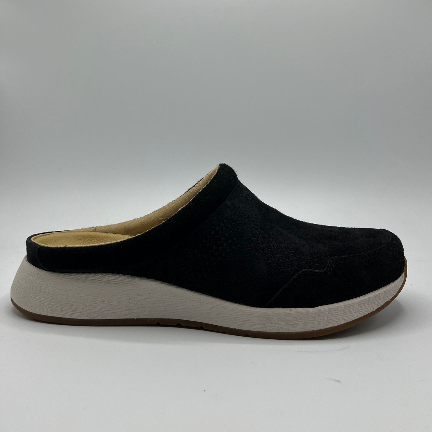 Black slip-on shoe with a white sole on a gray background