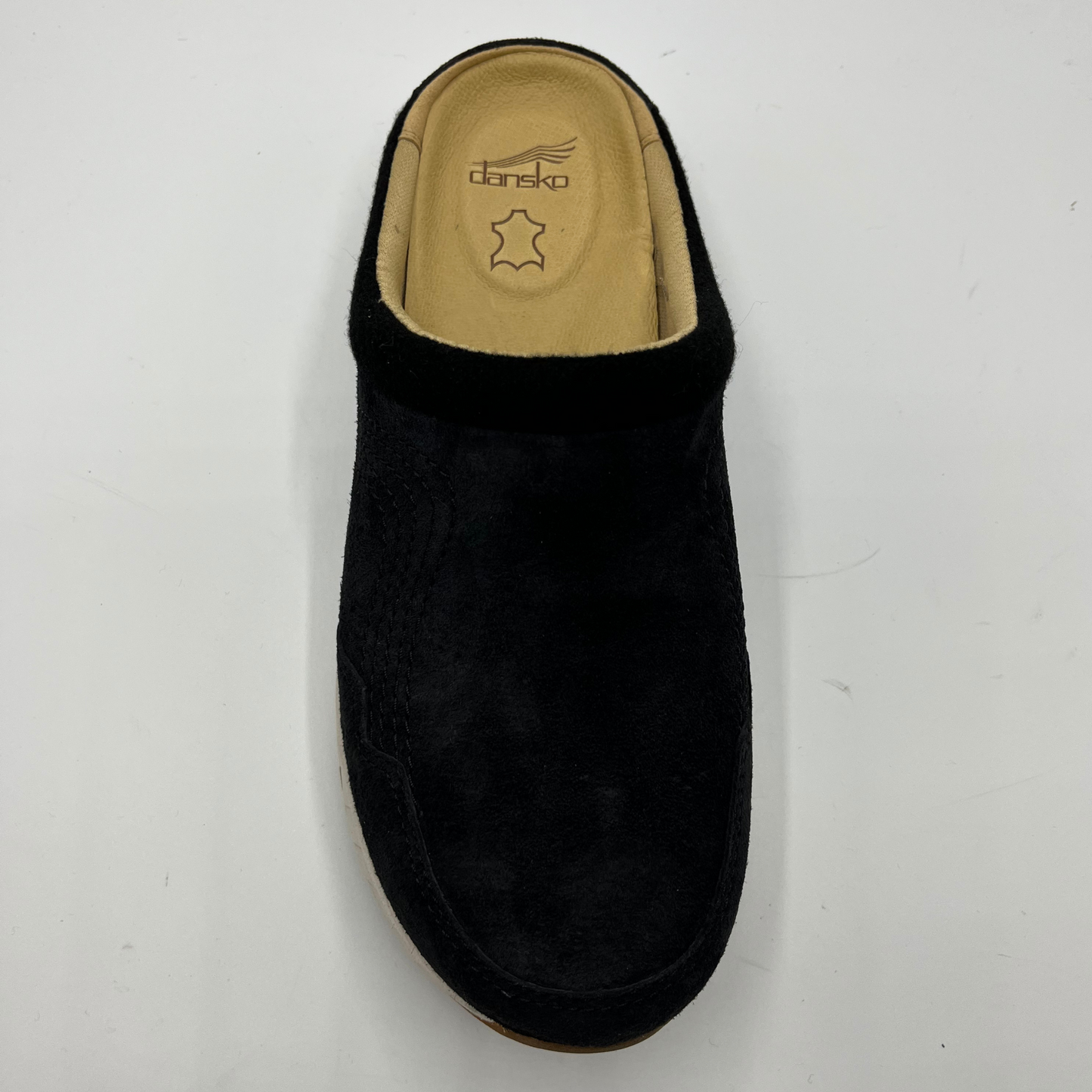 Black slipper with tan interior on a white background