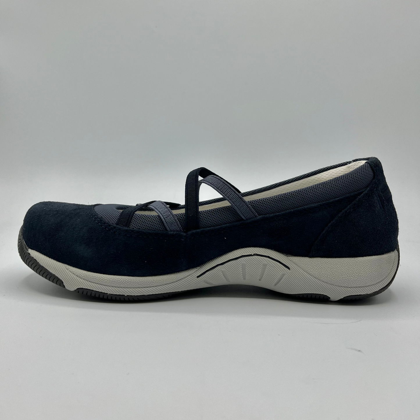 Navy blue shoe with a white sole on a gray background
