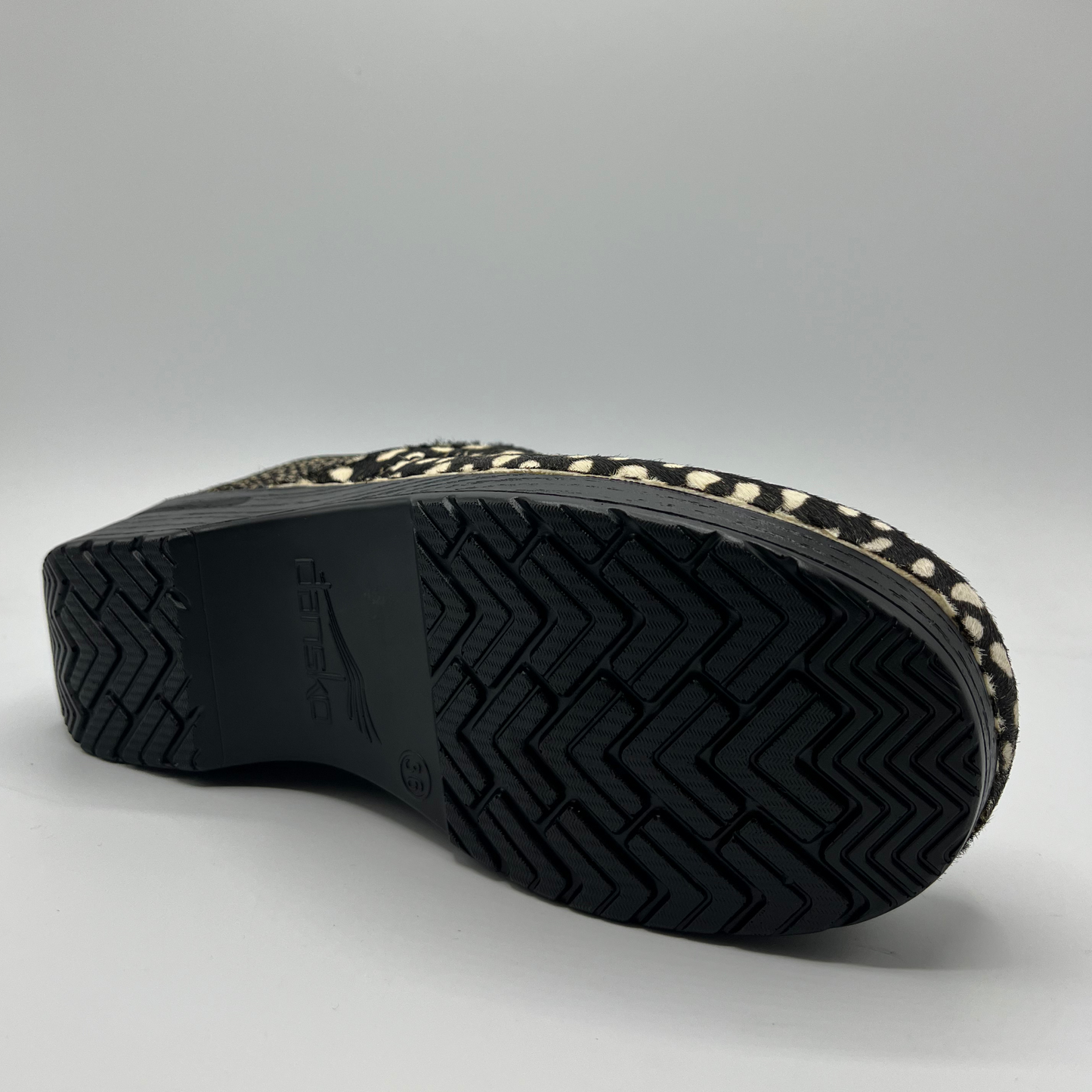 Close-up of a shoe sole with a textured pattern on a gray background