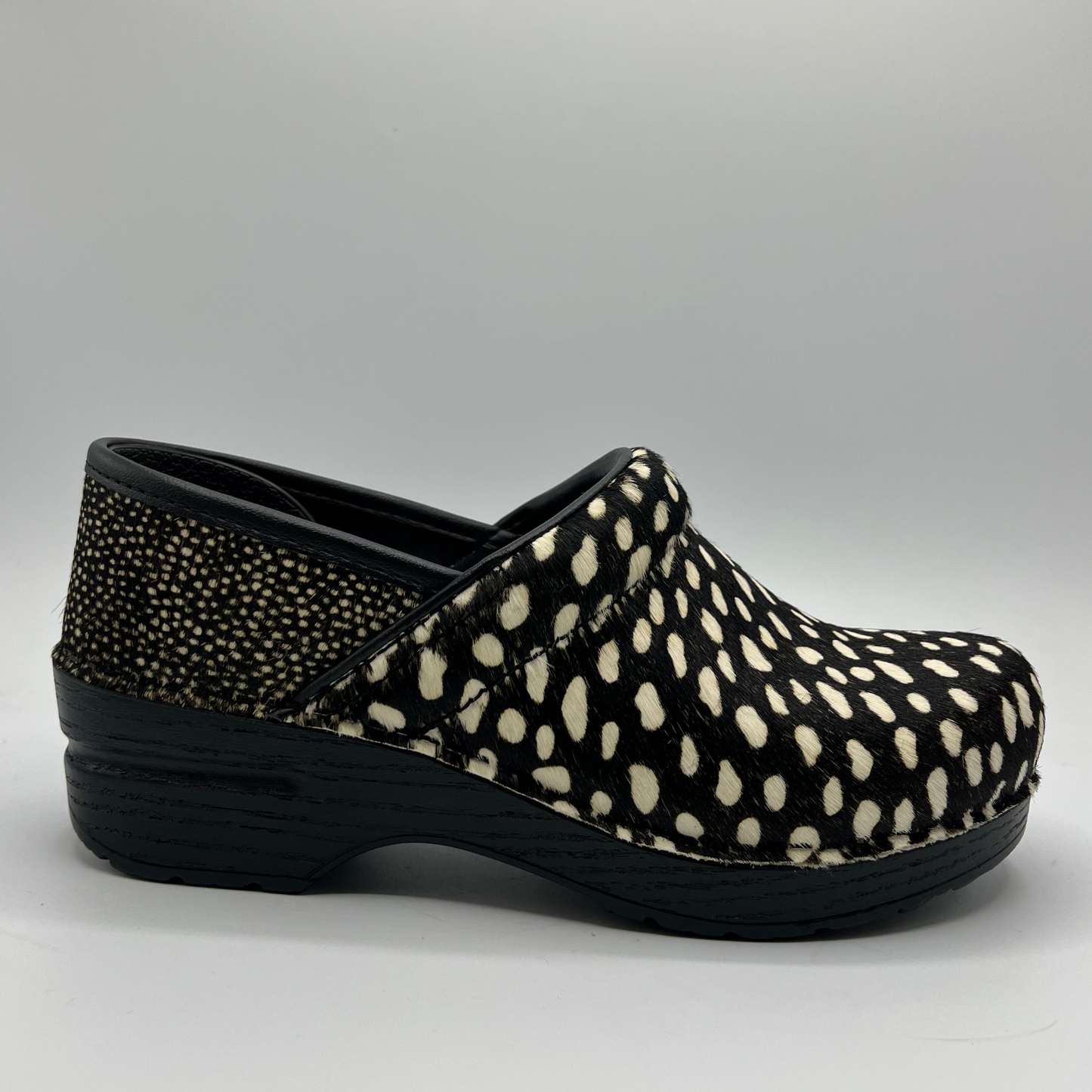 Black and white polka dot clog shoe on a gray background