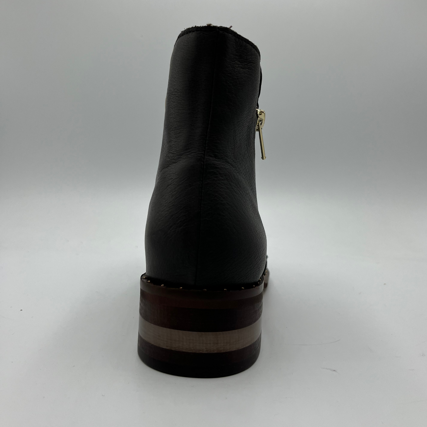 Back view of a leather ankle boot with a gold zipper