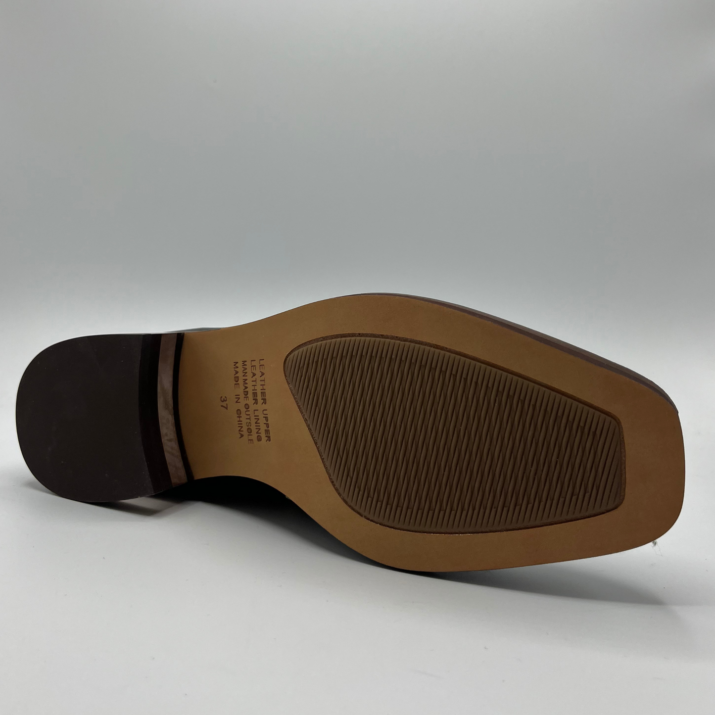 Bottom view of a leather ankle boot with a gold zipper