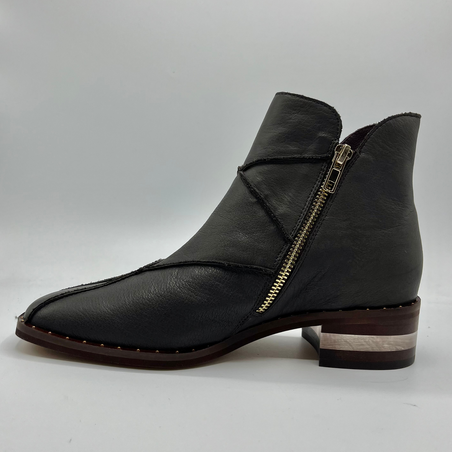 Left facing view of a leather ankle boot with a gold zipper