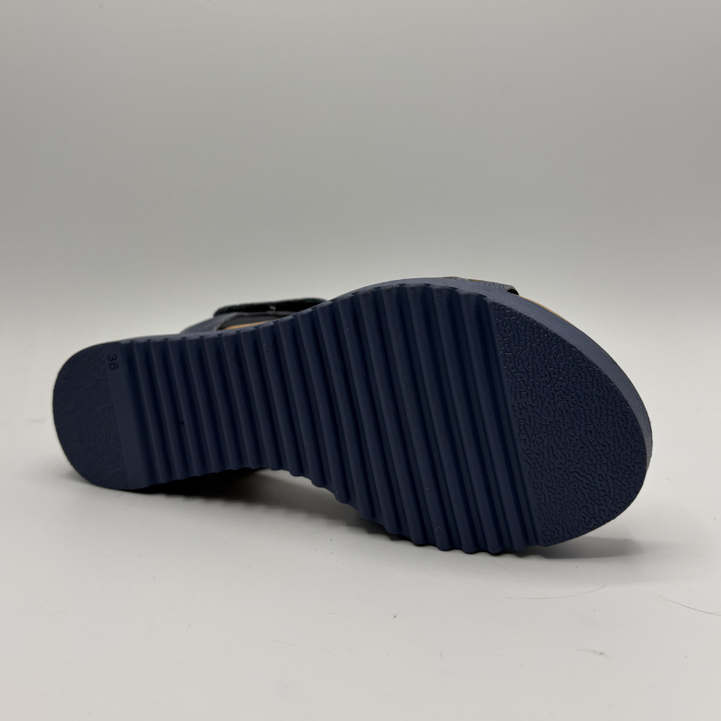 Navy blue sandal sole on a light gray background
