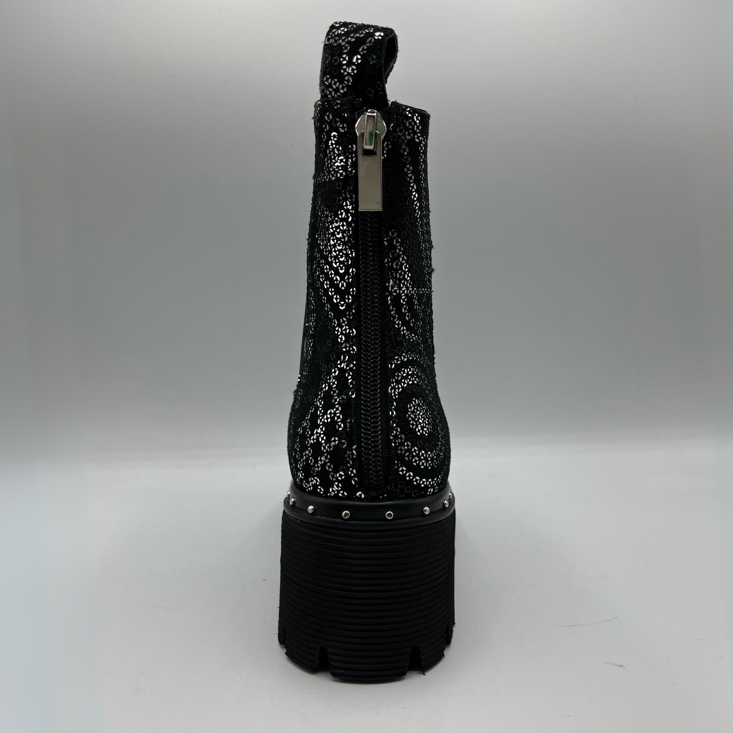 Black sequin boot with a platform sole on a gray background