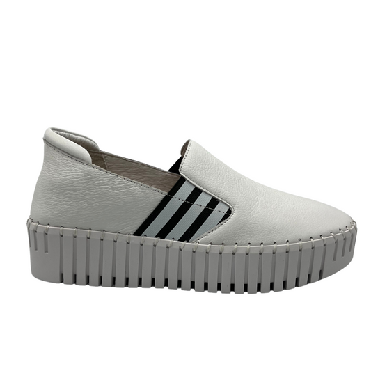 Right facing view of white leather slip on shoe with platform sole and stitched details around upper