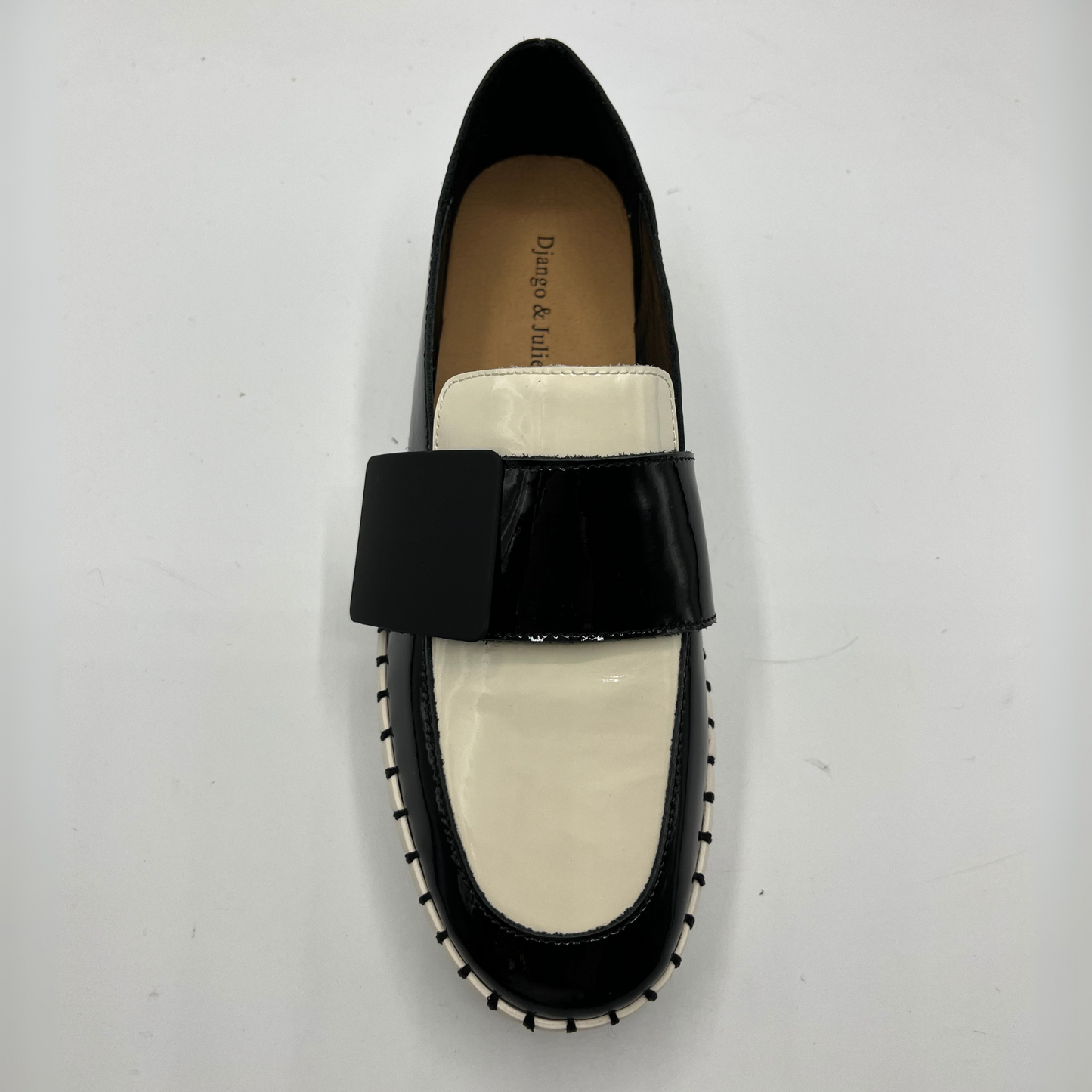 Black and white loafer shoe on a light gray background