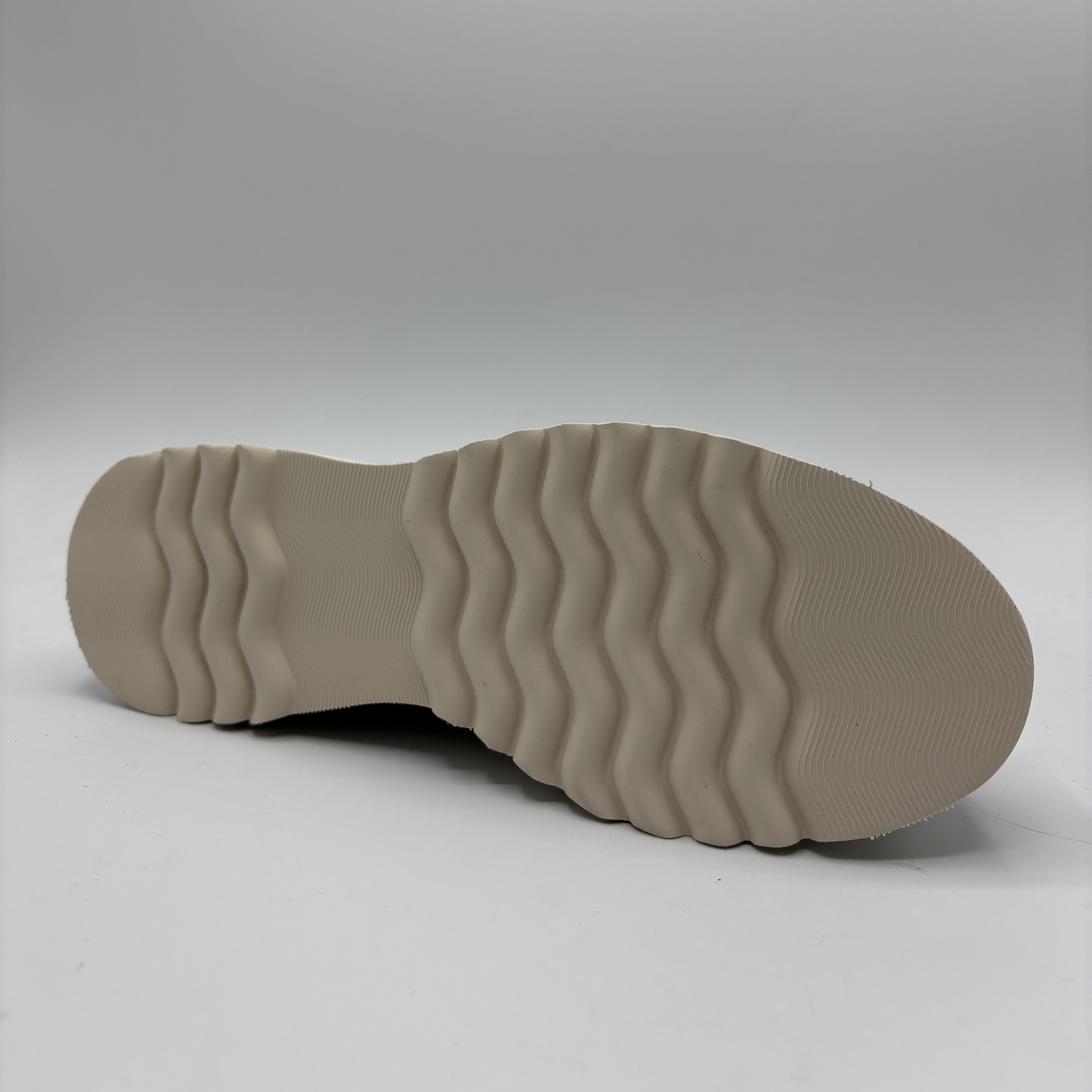 Close-up of a beige shoe sole on a light gray background