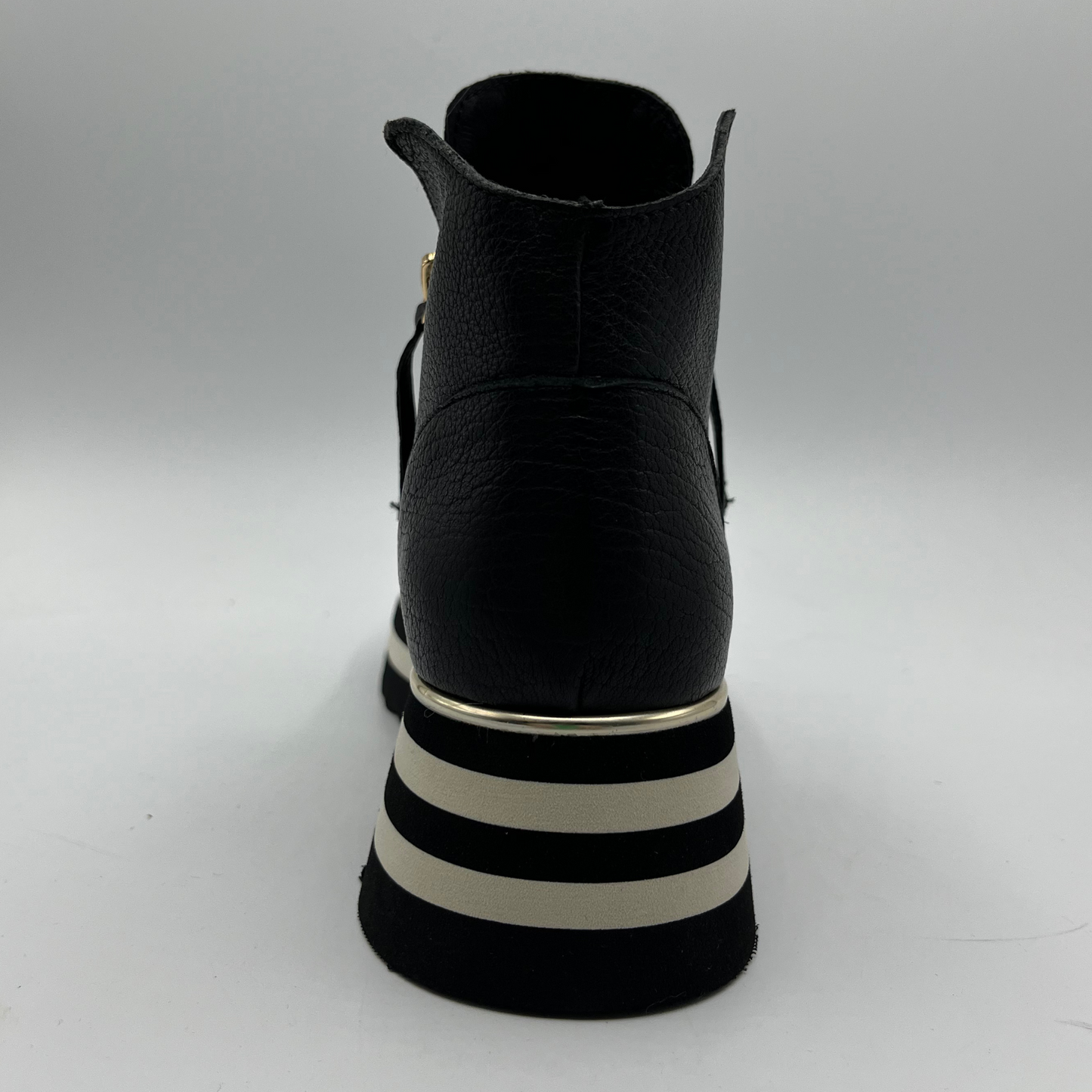Black ankle boot with striped sole on a white background
