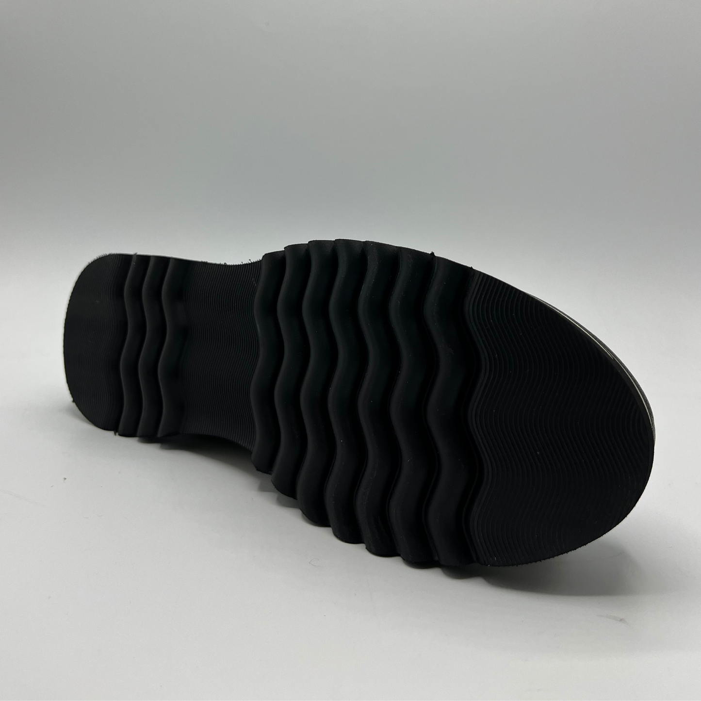 Black shoe sole on a light gray background