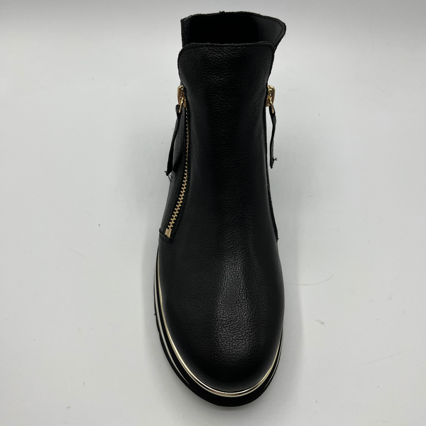 Black ankle boot with gold zipper on a white background