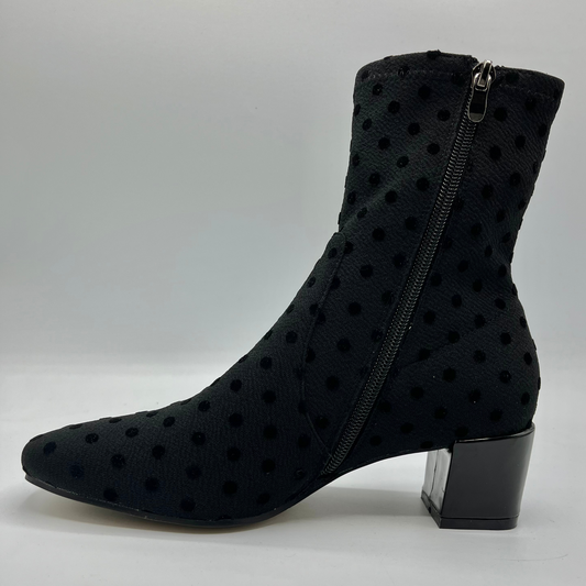Black polka dot ankle boot with a zipper on a white background