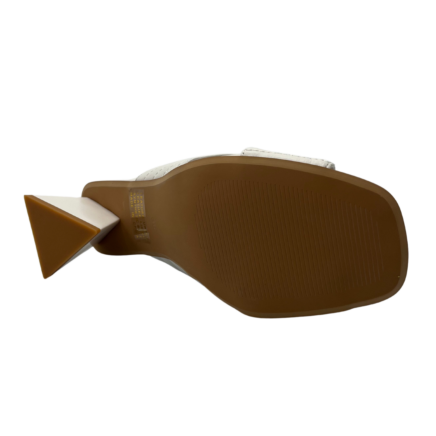Bottom view of white leather shoe with triangular shaped heel