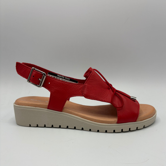 Red sandal with a beige sole on a gray background