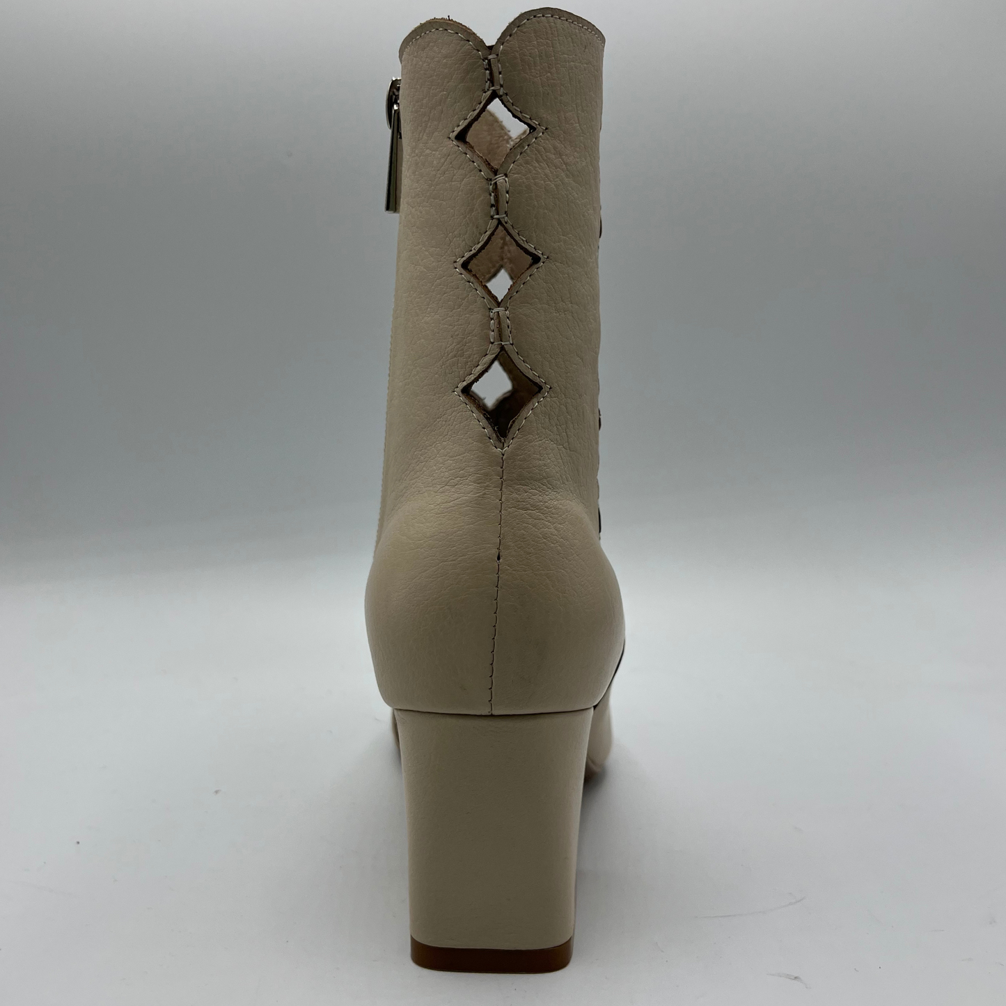 Beige ankle boot with cut-out design on a white background