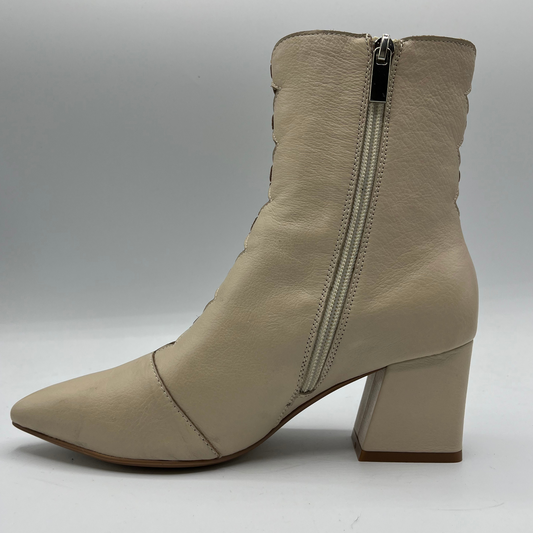 Beige ankle boot with a zipper on a gray background