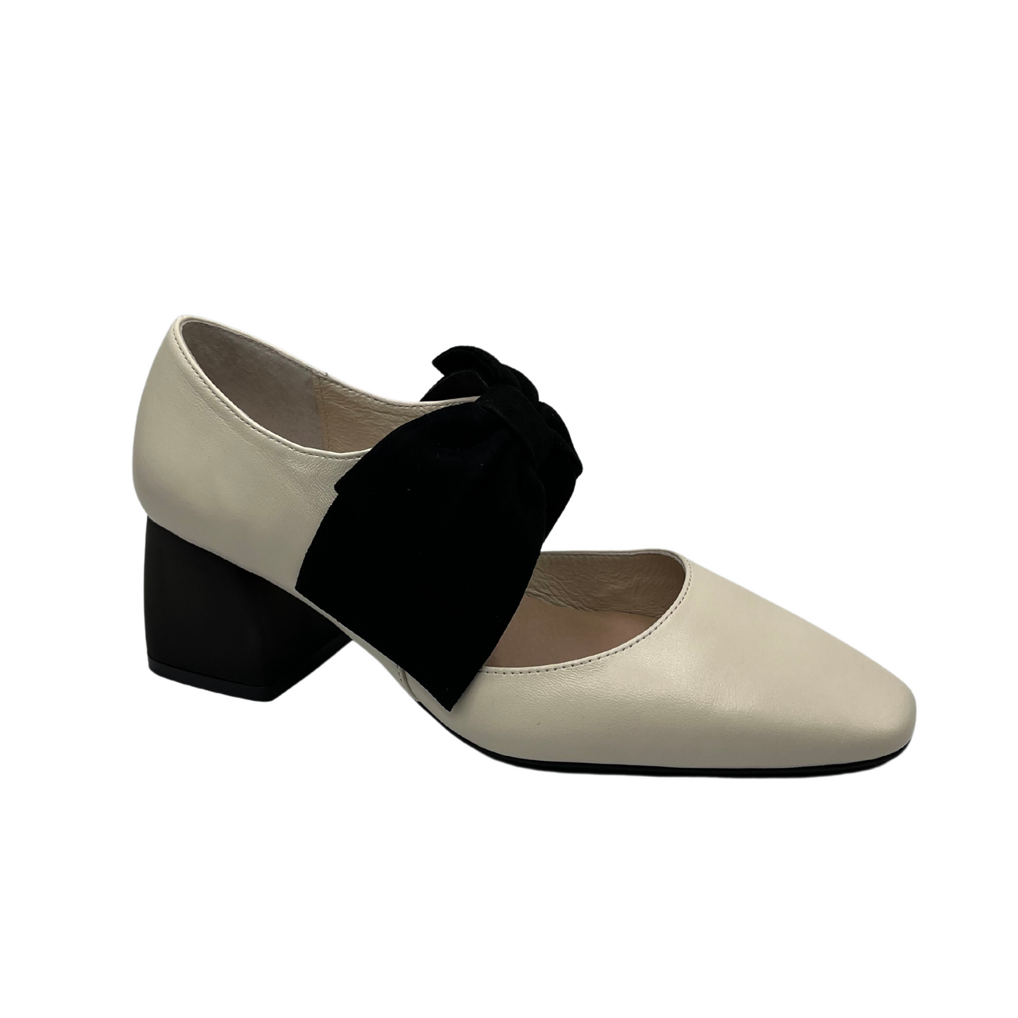 45 degree angled view of cream leather pump with black suede accent bow and short block heel