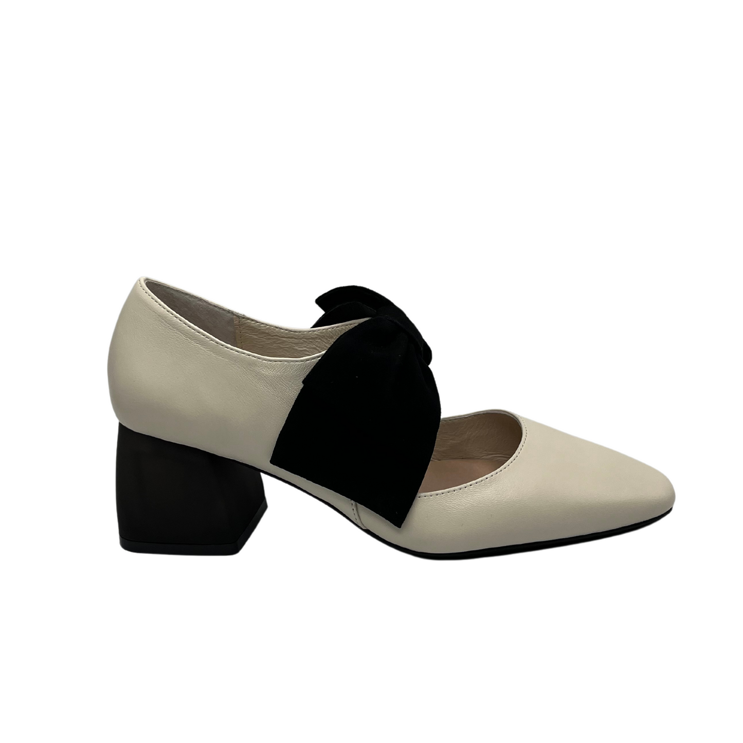 Right facing view of cream leather pump with black suede accent bow and short block heel
