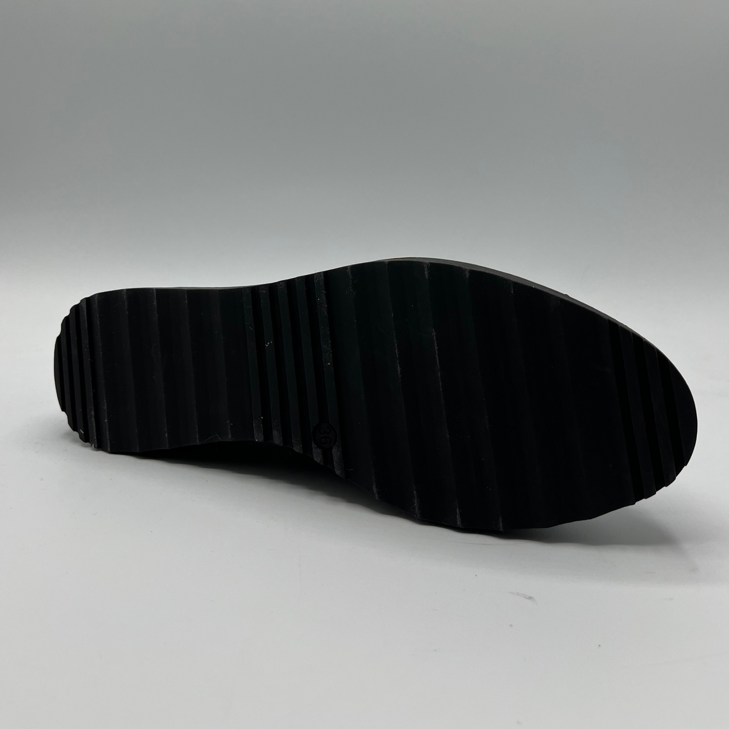 Black sole of a shoe on a gray background