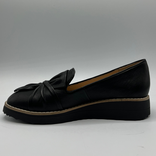 Black loafer shoe with a bow on a gray background
