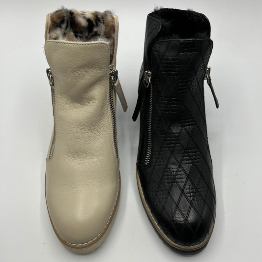 Beige and black ankle boots with fur lining on a white background