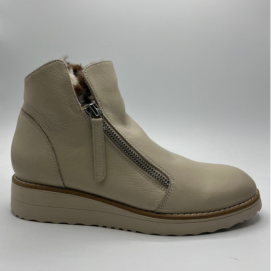 Beige ankle boot with faux fur lining and zipper on a white background