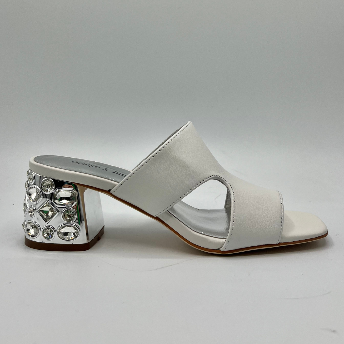 Right facing view of a white leather sandal with a 1/4" bejewelled heel and side cut outs.