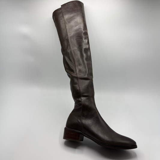 A single dark brown leather knee-high boot with a low stacked block heel, shown from a side profile against a light gray studio background.