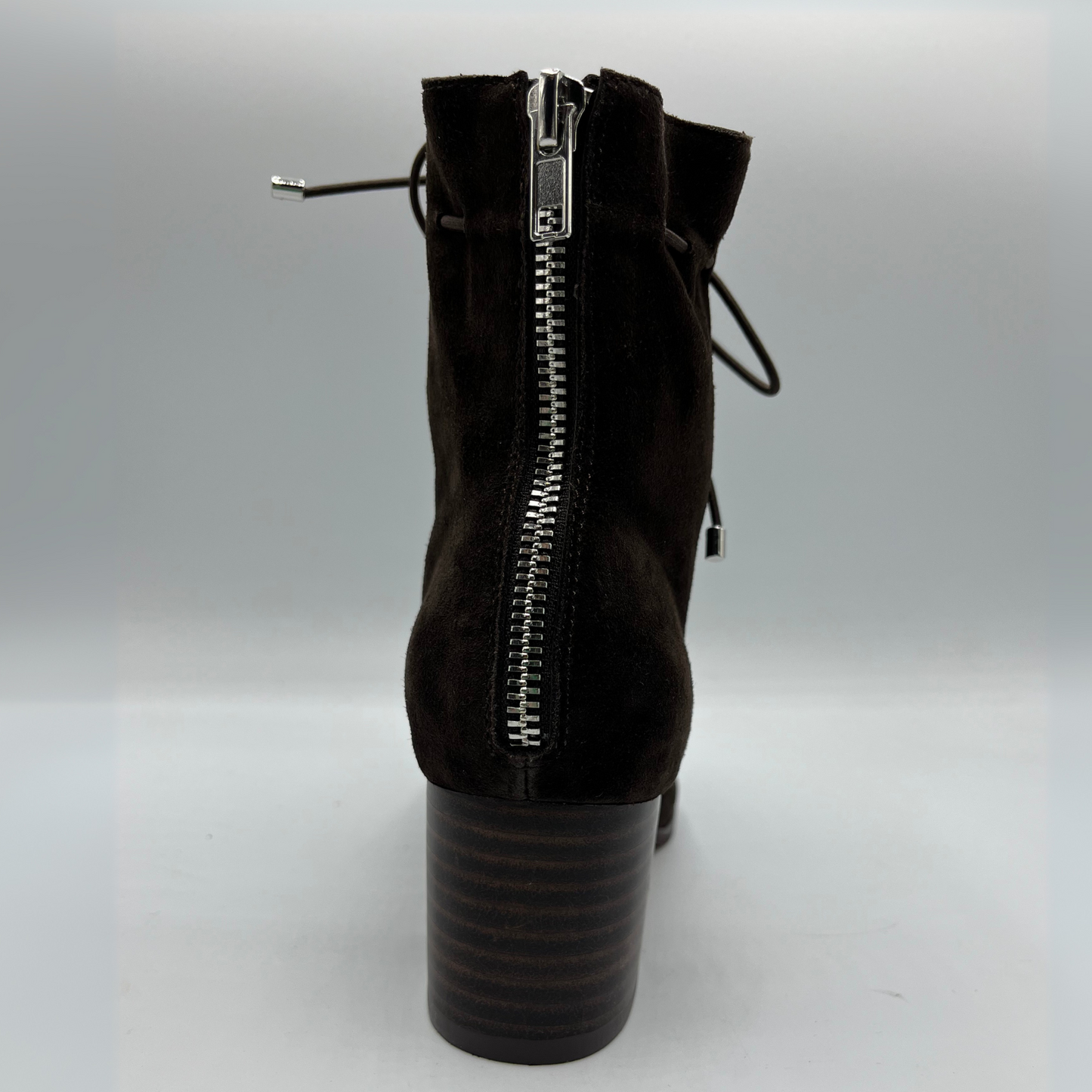 Back view of a chocolate leather with a chocolate patent leather toe cap. Stacked heel and unique tie up ankle