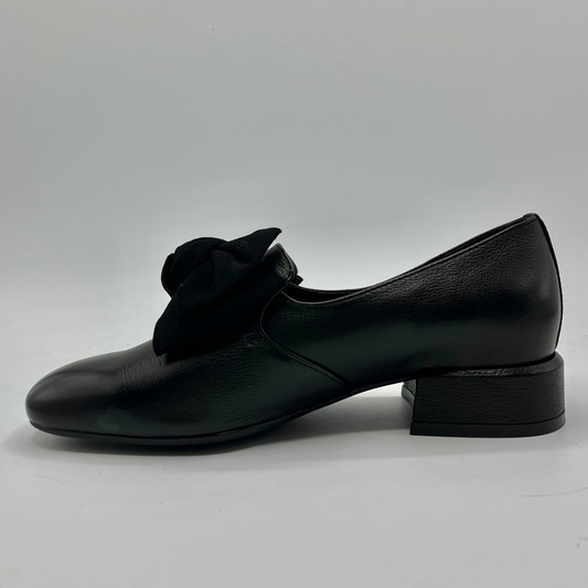 Black leather shoe with a bow on a gray background