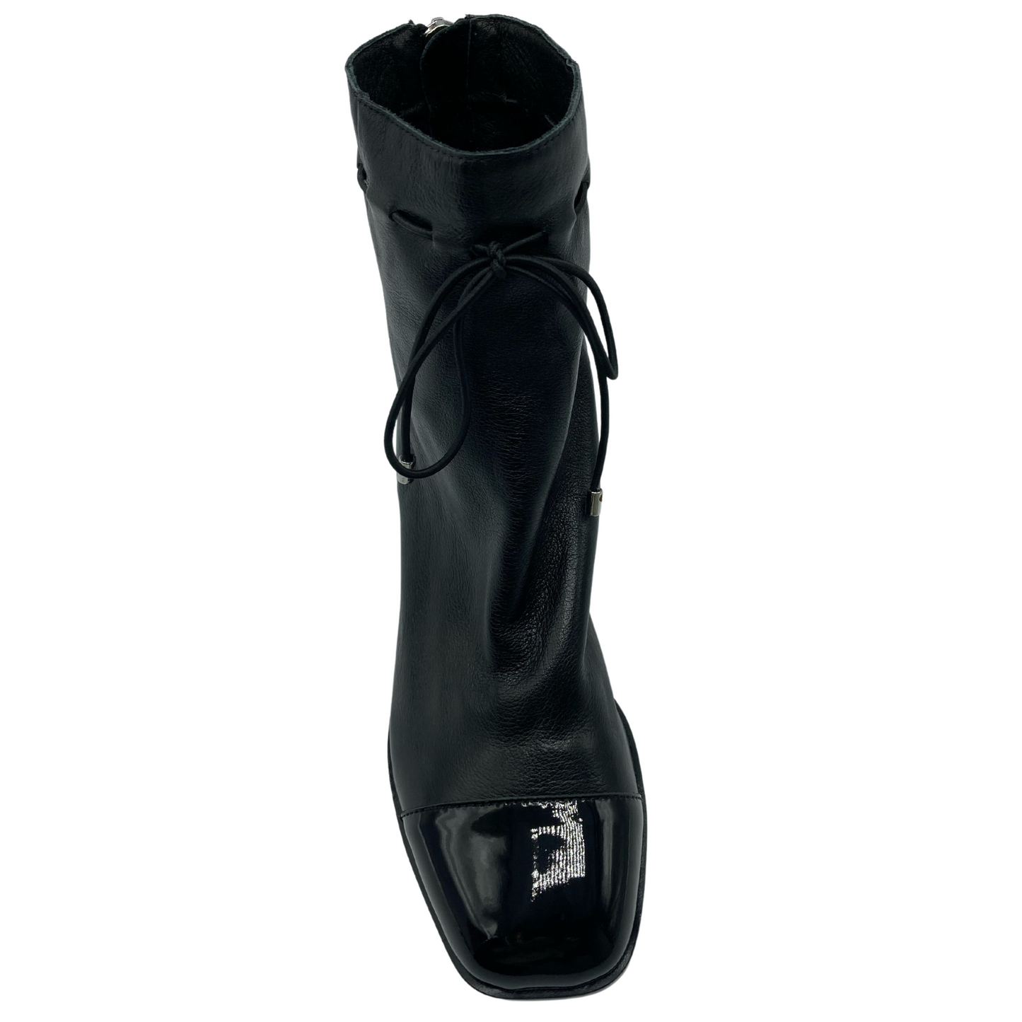 Top view of black leather ankle boot with patent toe cap.