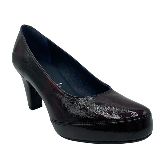 45 degree angled view of patent leather pump with mid height heel and pointed toe
