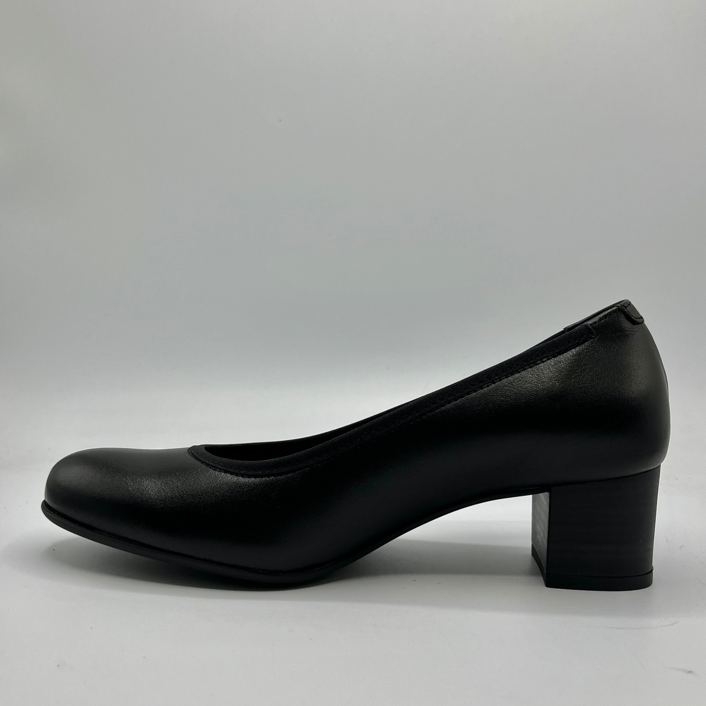 Black shoe with a block heel on a gray background