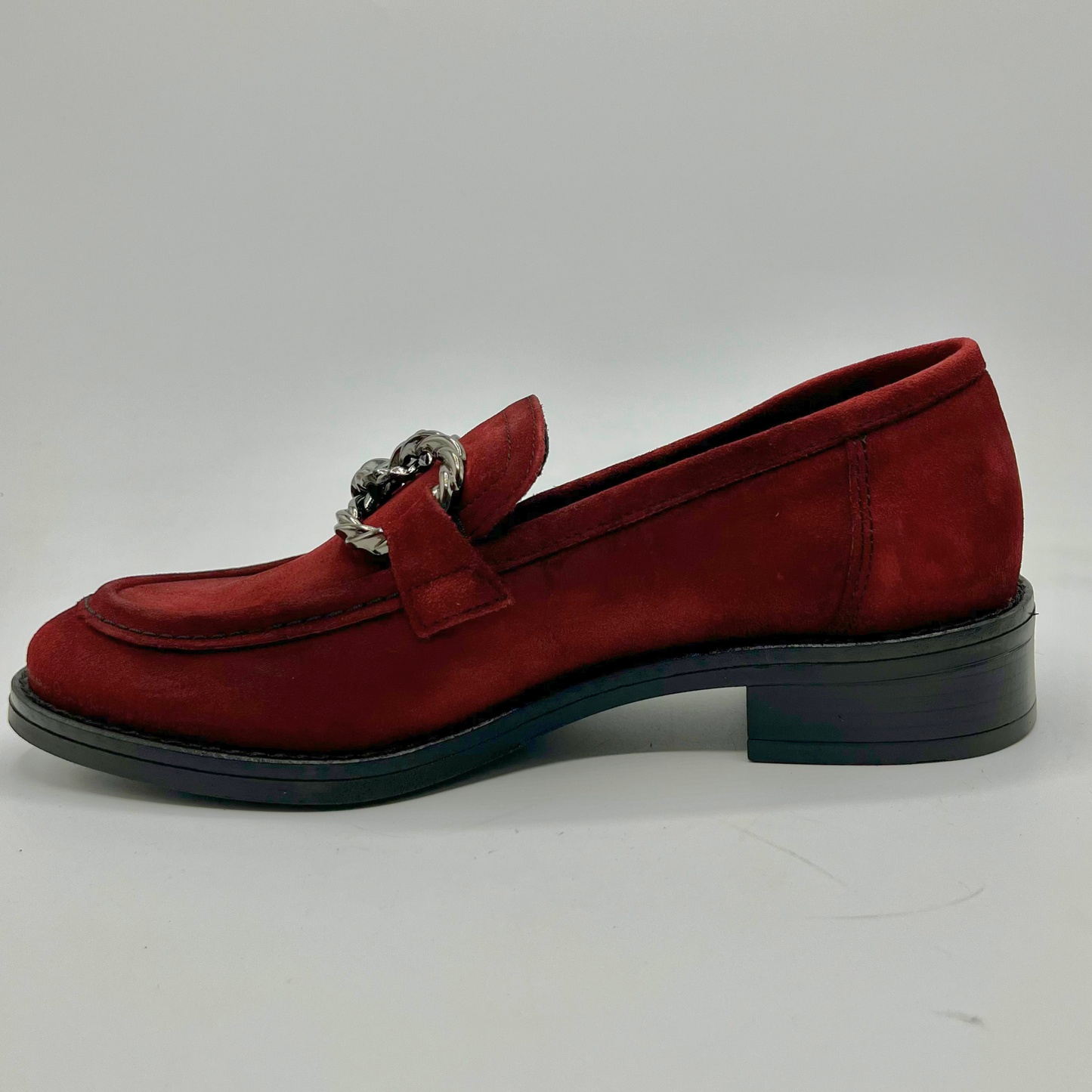 Red loafer shoe with a silver buckle on a white background