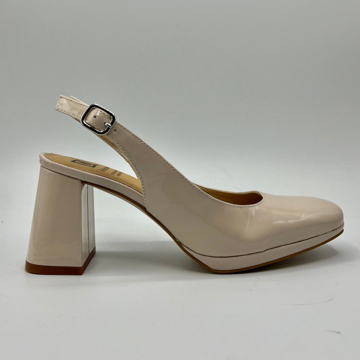 Right facing view of a nude patent leather high heeled shoe with an adjustable sling back strap and a leather insole.