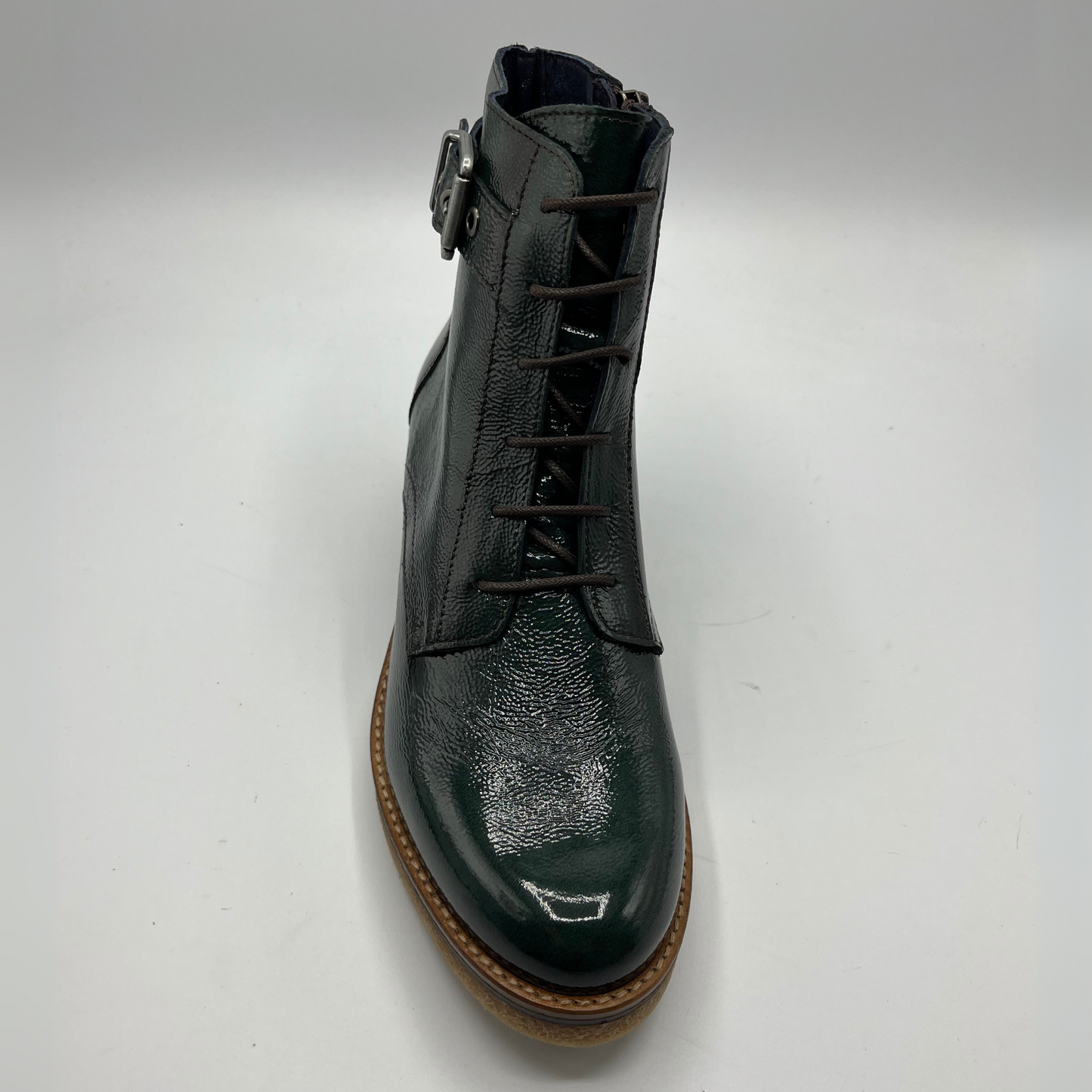 Green leather boot with brown sole on a white background