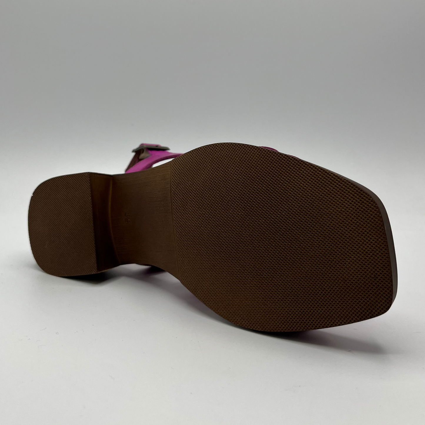 Bottom view of a fucsia coloured sandal with an adjustable slingback strap, stacked heel and cushioned insole.
