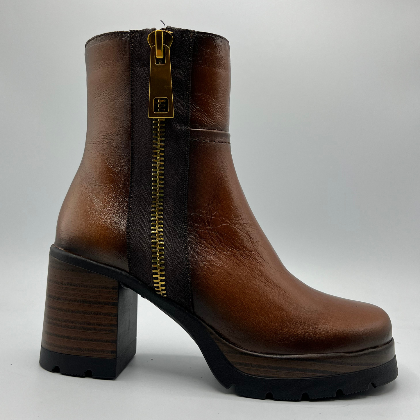 Brown leather boot with a gold zipper on a white background